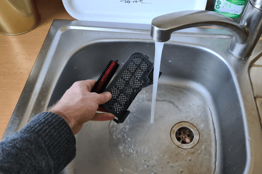 Чистящая щетка и фильтр промываются под проточной водой.